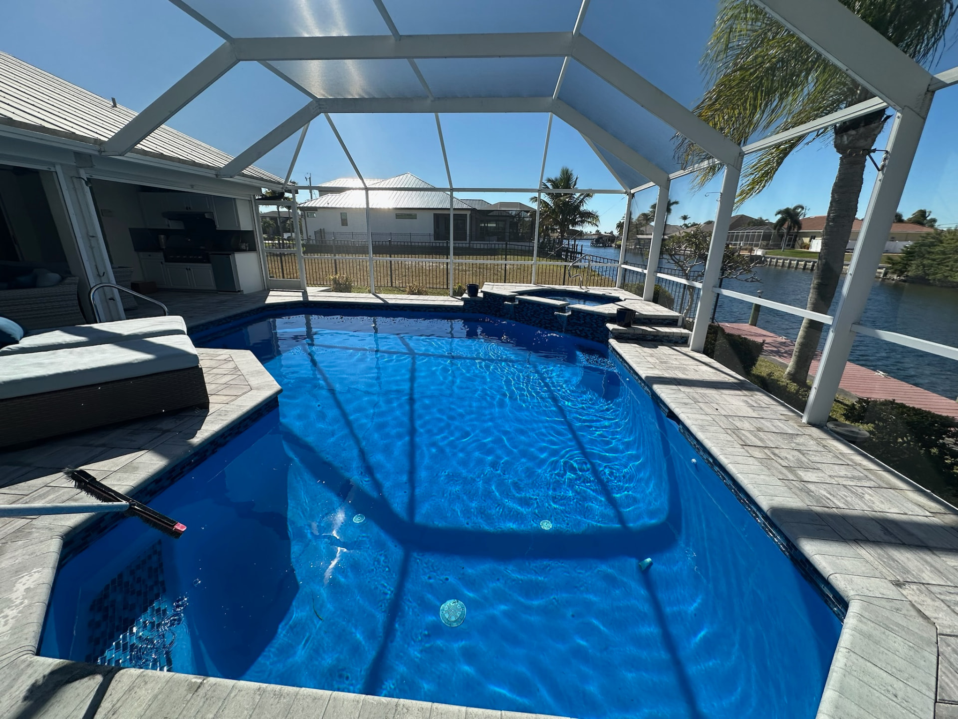 Resurfaced screened-in pool and spa with a deep blue interior finish