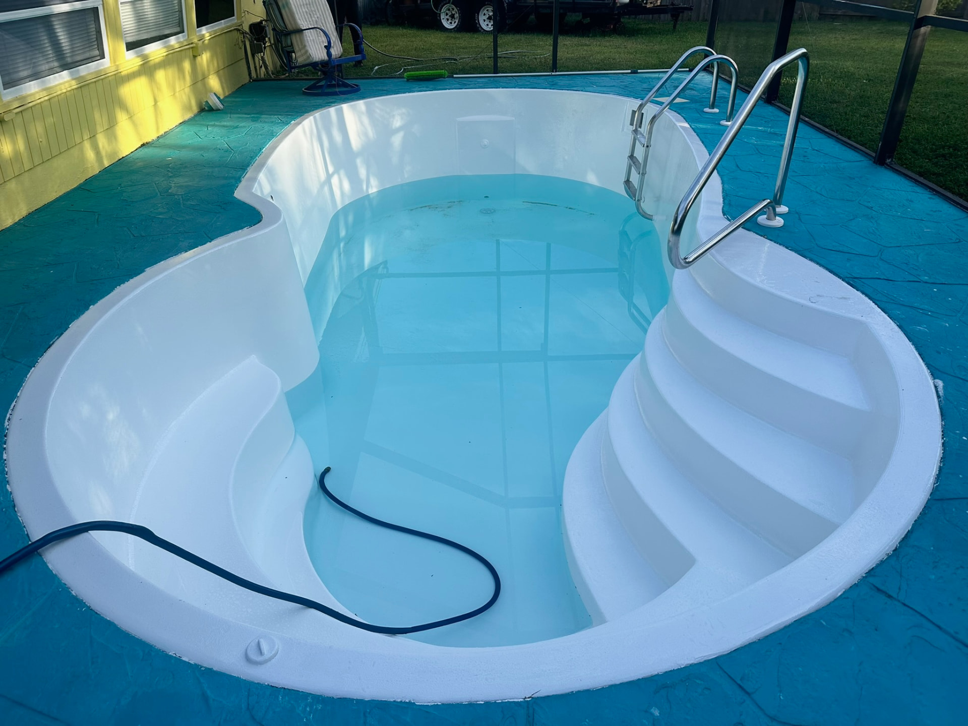 Restored fiberglass pool filled with clean water and a bright white finish